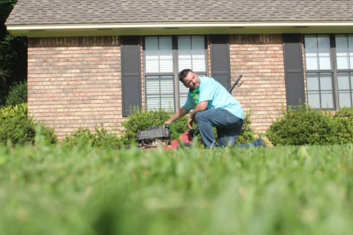 Man preparing to mow the lawn in front of a house