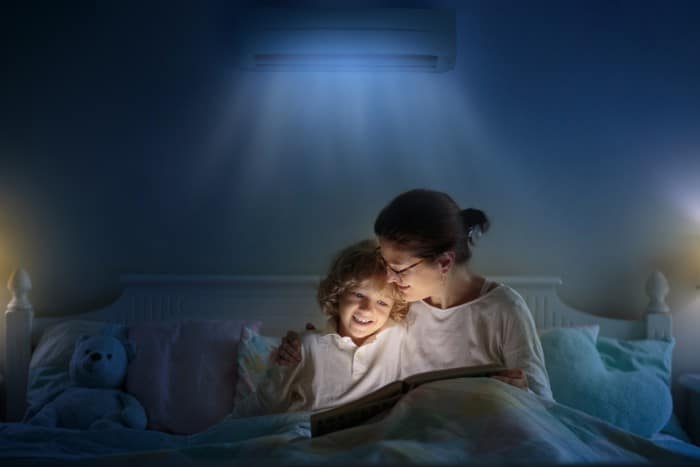 Mother and son bedtime clean indoor air Mother and child enjoying bedtime story under clean, fresh air from an air conditioning system