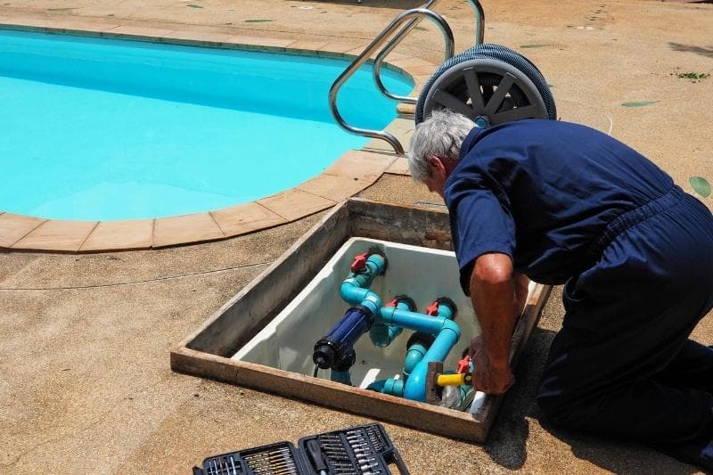 pool technician checking a swimming pool motor pump