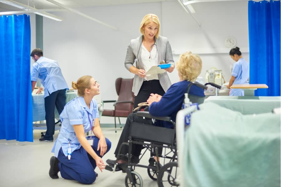 a knee doctor talking to a patient in a wheelchair