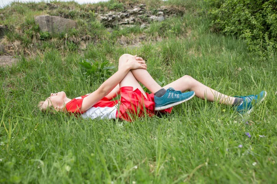 athletic boy in excruciating pain holding his injured knee