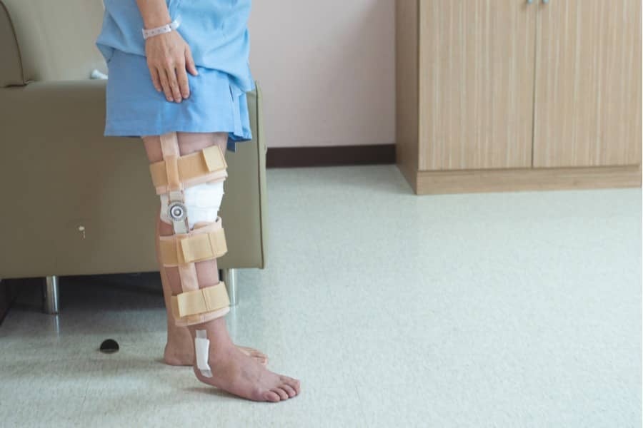 patient standing with support of knee brace